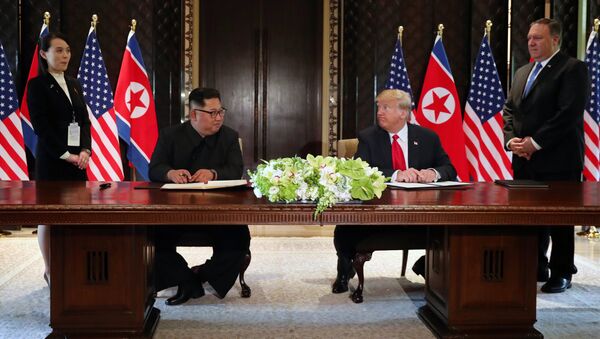 U.S. President Donald Trump and North Korea's leader Kim Jong Un look at each others before signing documents that acknowledge the progress of the talks and pledge to keep momentum going, after their summit at the Capella Hotel on Sentosa island in Singapore June 12, 2018 - Sputnik International
