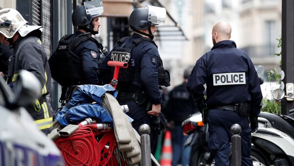 French police and a fireman secure the street as a man has taken people hostage at a business in Paris, France, June 12, 2018 - Sputnik International