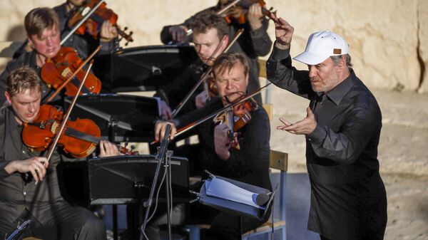 In this Thursday, May 5, 2016 photo provided by Russian Defense Ministry Press Service, the renowned conductor Valery Gergiev, right, leads a performance by the Mariinsky Symphony Orchestra from St. Petersburg, during the concert at the UNESCO world heritage site of Palmyra, the central city of Homs, Syria - Sputnik International
