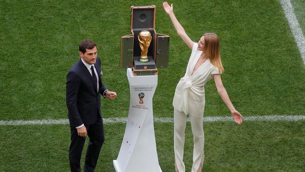 Soccer Football - World Cup - Opening Ceremony - Luzhniki Stadium, Moscow, Russia - June 14, 2018 Iker Casillas and model Natalia Vodianova present the World Cup trophy before the ceremony - Sputnik International