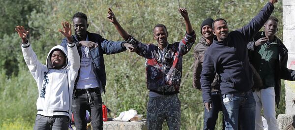 Migrants dance and cheer as they assist at the start of the citizens and solidarity march, in Ventimiglia, an Italian city near the border between Italy and France, on April 30, 2018. Some 60 people, gathered on April 30, 2018 in Ventimiglia at the French and Italian border - Sputnik International