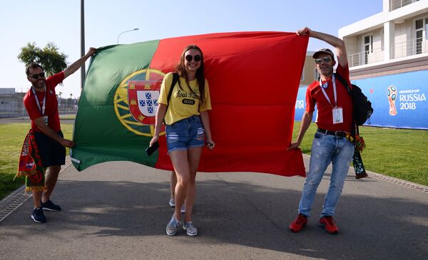 Fans of Portugal's team posing in front of the country's flag ahead of a group stage World Cup match between Spain and Portugal. - Sputnik International