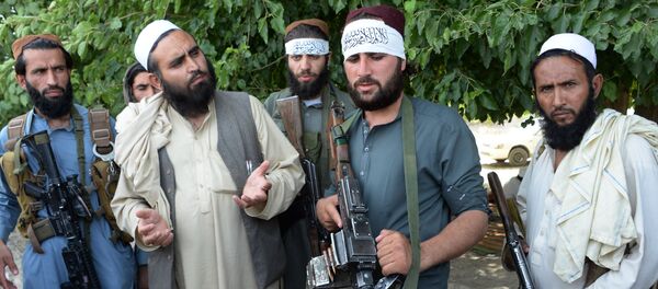 Afghan Taliban militants stand with residents as they took to the street to celebrate ceasefire on the second day of Eid in the outskirts of Jalalabad on June 16,2018 - Sputnik International