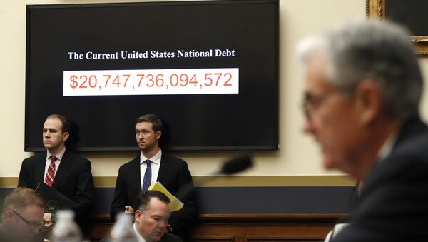 The National debt is shown behind Federal Reserve Chairman Jerome Powell as he testifies on the semiannual monetary policy report to the House Financial Services Committee, Tuesday, Feb. 27, 2018, in Washington - Sputnik International