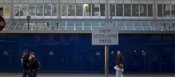 A tourist poses for a photograph by the rotating sign outside New Scotland Yard, the headquarters building of London's Metropolitan Police force in central London A tourist poses for a photograph by the rotating sign outside New Scotland Yard, the headquarters building of London's Metropolitan Police force in central London - Sputnik International
