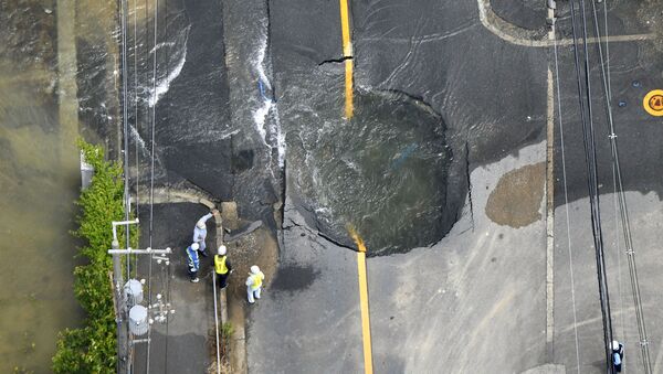 Water flows out from cracks in a road damaged by an earthquake in Takatsuki, Osaka prefecture, western Japan, in this photo taken by Kyodo June 18, 2018. - Sputnik International