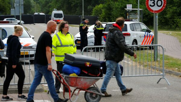 Visitiors leave the festival grounds as police are seen near a scene where a van struck into people after a concert in Landgraaf, the Netherlands June 18, 2018 - Sputnik International
