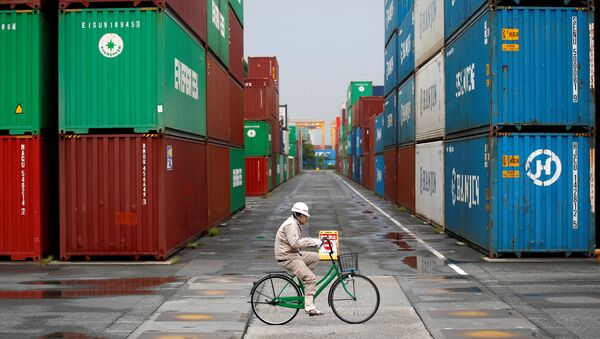 A worker rides a bicycle in a container area at a port in Tokyo (File) - Sputnik International