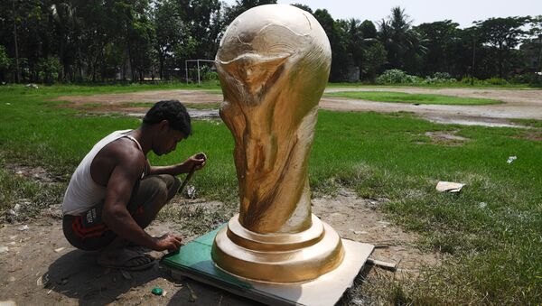 An Indian artisan works on clay model of the FIFA world cup trophy ordered by football fan clubs for decoration, ahead of the upcoming FIFA Russia 2018 World Cup, in Kolkata on June 13, 2018 - Sputnik International
