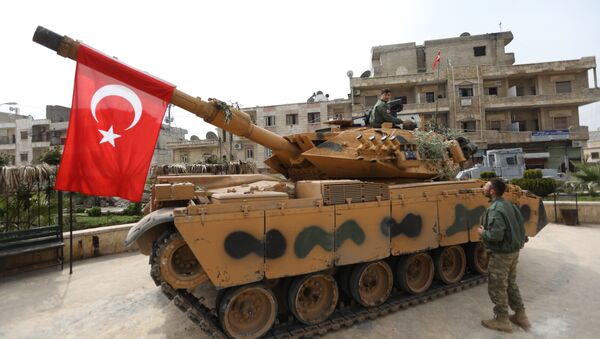 A tank belonging to Turkish soldiers and Ankara-backed Syrian Arab fighters is seen in the Kurdish-majority city of Afrin in northwestern Syria after they took control of it from Kurdish People's Protection Units (YPG) on March 18, 2018 - Sputnik International