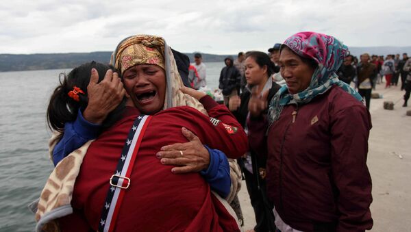 Relatives cry while waiting for news on missing family members who were on a ferry that sank yesterday in Lake Toba, at Tigaras Port, Simalungun, North Sumatra, Indonesia June 19, 2018 - Sputnik International