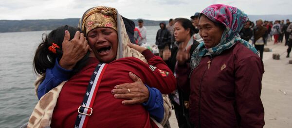 Relatives cry while waiting for news on missing family members who were on a ferry that sank yesterday in Lake Toba, at Tigaras Port, Simalungun, North Sumatra, Indonesia June 19, 2018 - Sputnik International