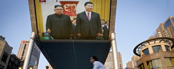 People bicycle past a giant TV screen broadcasting the meeting of North Korean leader Kim Jong Un and Chinese President Xi Jinping during a welcome ceremony at the Great Hall of the People in Beijing, Tuesday, June 19, 2018 People bicycle past a giant TV screen broadcasting the meeting of North Korean leader Kim Jong Un and Chinese President Xi Jinping during a welcome ceremony at the Great Hall of the People in Beijing, Tuesday, June 19, 2018 - Sputnik International