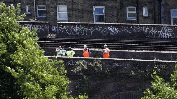 British Transport Police and railway workers inspect the scene where three graffiti artists died on Monday, June 18 - Sputnik International