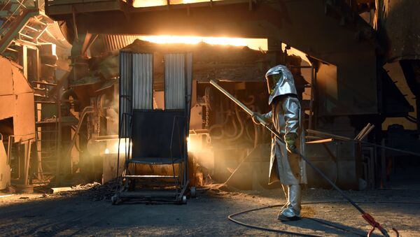 A steelworker in a protective suit checks the temperature of molten metal in furnace at the TMK Ipsco Koppel plant in Koppel, Pennsylvania on March 9, 2018 - Sputnik International