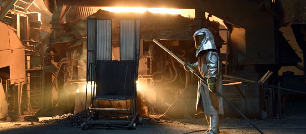 A steelworker in a protective suit checks the temperature of molten metal in furnace at the TMK Ipsco Koppel plant in Koppel, Pennsylvania on March 9, 2018 - Sputnik International