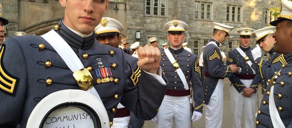 In this May 2016 photo provided by Spenser Rapone, Rapone raises his left fist while displaying a sign inside his hat that reads Communism will win, after graduating from the United States Military Academy at West Point, N.Y. In this May 2016 photo provided by Spenser Rapone, Rapone raises his left fist while displaying a sign inside his hat that reads Communism will win, after graduating from the United States Military Academy at West Point, N.Y. - Sputnik International