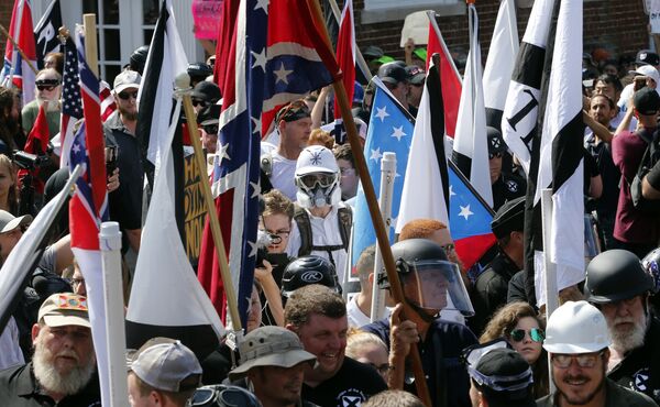 In this Saturday, Aug. 12, 2017, file photo, white nationalist demonstrators walk into the entrance of Lee Park surrounded by counter demonstrators in Charlottesville, Va. In this Saturday, Aug. 12, 2017, file photo, white nationalist demonstrators walk into the entrance of Lee Park surrounded by counter demonstrators in Charlottesville, Va. - Sputnik International