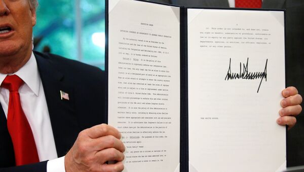 U.S. President Donald Trump displays an executive order on immigration policy after signing it in the Oval Office at the White House in Washington, U.S., June 20, 2018. - Sputnik International