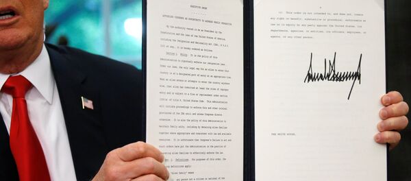 U.S. President Donald Trump displays an executive order on immigration policy after signing it in the Oval Office at the White House in Washington, U.S., June 20, 2018. - Sputnik International