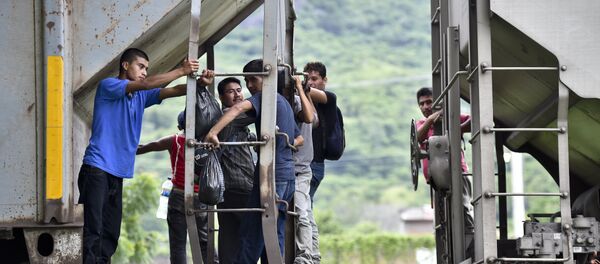 Central American migrants ride the train called The Beast in their attemp to reach the border between Mexico and the United States on September 1, 2014 in Arriaga, Chiapas state, Mexico. - Sputnik International