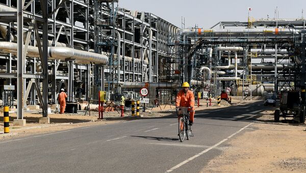 In this photograph taken on December 11, 2015, a worker cycles by machinery at Cairn India, Oil and Gas exploration plant at Barmer in Rajasthan - Sputnik International