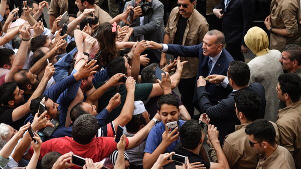 Turkey's President Recep Tayyip Erdogan, leader of the Justice and Development Party (AKP) and his wife Emine are greeted by supporters as they leave the polling station after casting their votes during snap twin Turkish presidential and parliamentary elections in Istanbul on June 24, 2018 - Sputnik International