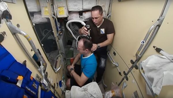 The Russian State Corporation Roscosmos has published a 360-degree video on its website showing Russian cosmonaut Anton Shkaplerov cutting his colleague Alexander Misurkin's hair on board the International Space Station - Sputnik International
