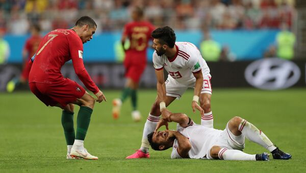 Portugal's Cristiano Ronaldo reacts as Iran's Morteza Pouraliganji is on the floor. File photo - Sputnik International