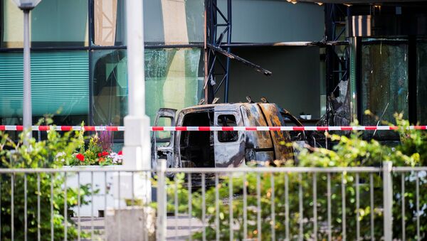 A van is seen burned out after crashing into the glass facade of the head office of Dutch newspaper De Telegraaf in what police said was a deliberate action in Amsterdam, Netherlands June 26, 2018 - Sputnik International