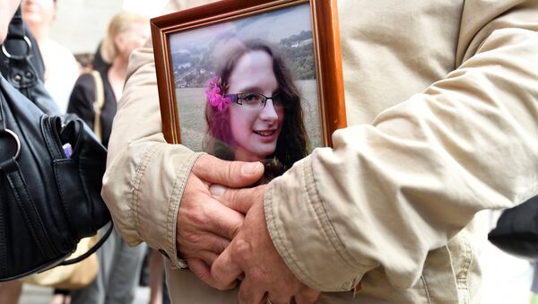 FILES) In this file photo taken on June 6, 2018 a man holds a picture of murdered French au-pair Sophie Lionnet after her funeral in Sens - Sputnik International