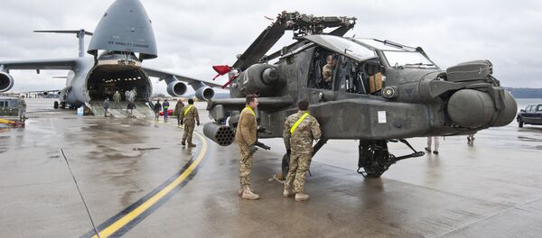 An AH-64 Apache attack helicopter stands in front of a Galaxy C-5 transport plane at the US Air Base in Ramstein, western Germany, on February 22, 2017. An AH-64 Apache attack helicopter stands in front of a Galaxy C-5 transport plane at the US Air Base in Ramstein, western Germany, on February 22, 2017. - Sputnik International