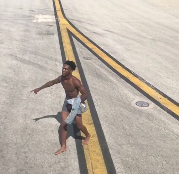 A man in underpants gestures as he walks to a plane on the tarmac at the airport in Atlanta, Georgia, U.S., June 26, 2018 in this picture obtained from social media A man in underpants gestures as he walks to a plane on the tarmac at the airport in Atlanta, Georgia, U.S., June 26, 2018 in this picture obtained from social media - Sputnik International