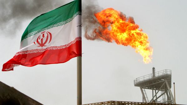 A gas flare on an oil production platform in the Soroush oil fields is seen alongside an Iranian flag in the Persian Gulf, Iran, July 25, 2005 - Sputnik International