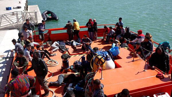Migrants of a group intercepted aboard dinghies off the coast in the Strait of Gibraltar, are seen on a rescue boat after arriving at the port of Barbate, southern Spain, June 27, 2018 - Sputnik International