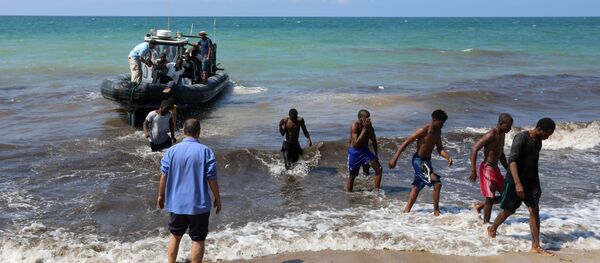 Migrants leave a boat at the coast of Tajoura, east of Tripoli, Libya June 20, 2018 - Sputnik International