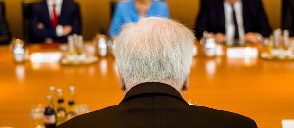German Interior Minister Horst Seehofer, front, sits on the opposite of German German Chancellor Angela Merkel, center back ground, prior to the weekly cabinet meeting of the German government at the chancellery in Berlin, Wednesday, June 13, 2018. - Sputnik International