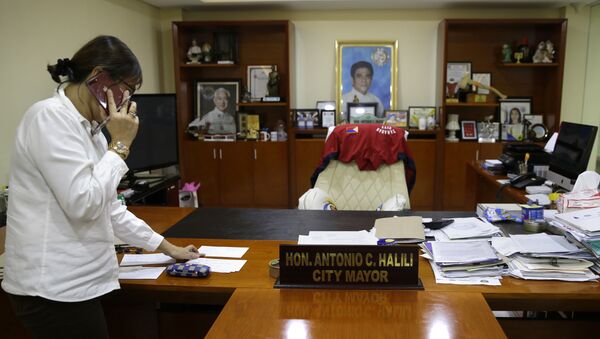A staff member of Tanauan city Mayor Antonio Halili arranges items inside his office after he was killed earlier in Batangas province, south of Manila on Monday, July 2, 2018 - Sputnik International