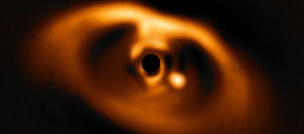 The photo provided by the European Southern Observatory ESO taken from the SPHERE instrument on ESO's Very Large Telescope is the first clear image of a planet caught in the very act of formation around the dwarf star PDS 70. - Sputnik International