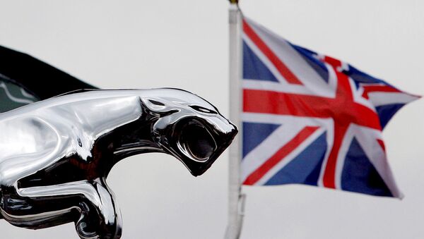 A Union flag is seen behind a Jaguar car emblem outside a dealership in Manchester, England - Sputnik International