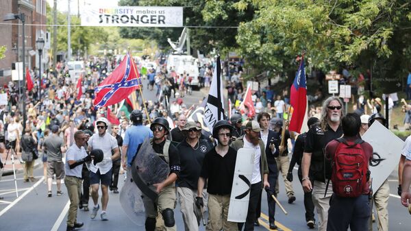 White nationalist demonstrators walk through town after their rally was declared illegal near Lee Park in Charlottesville, Va. - Sputnik International