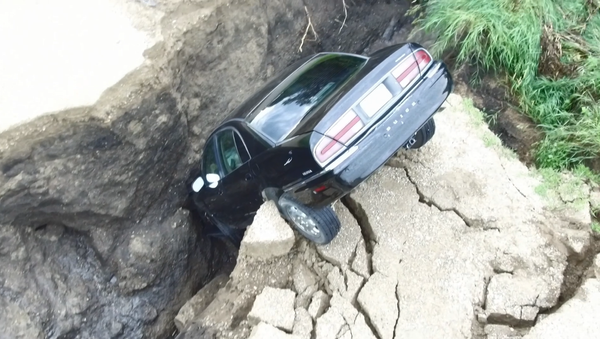 Screenshot From Drone Footage of a Minnesota Driver's Car that Plunged into a Hole Created by Rain, July 3, 2018 - Sputnik International