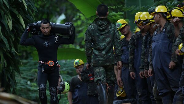 A diver carries an oxygen tank as he leaves the Tham Luang cave complex, where 12 boys and their soccer coach are trapped, in the northern province of Chiang Rai, Thailand, July 6, 2018 - Sputnik International