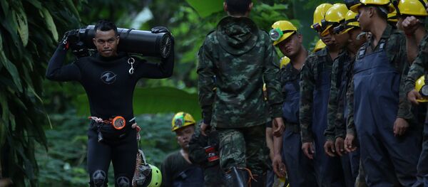 A diver carries an oxygen tank as he leaves the Tham Luang cave complex, where 12 boys and their soccer coach are trapped, in the northern province of Chiang Rai, Thailand, July 6, 2018 A diver carries an oxygen tank as he leaves the Tham Luang cave complex, where 12 boys and their soccer coach are trapped, in the northern province of Chiang Rai, Thailand, July 6, 2018 - Sputnik International