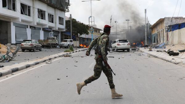 A Somali military officer runs to secure the scene of a suicide car bombing near Somalia's presidential palace in Mogadishu, Somalia July 7, 2018 - Sputnik International