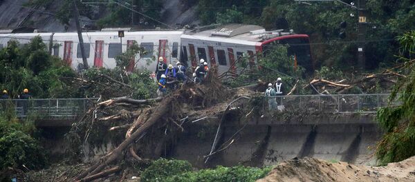 An emergency crew works at the site after a train derailed due to landslides caused by heavy rain in Karatsu city, Saga prefecture on July 7, 2018 - Sputnik International