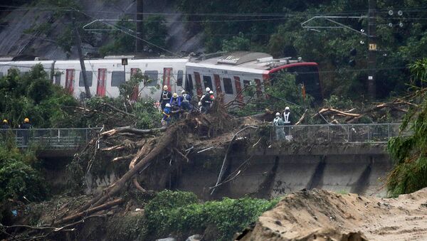 An emergency crew works at the site after a train derailed due to landslides caused by heavy rain in Karatsu city, Saga prefecture on July 7, 2018 - Sputnik International