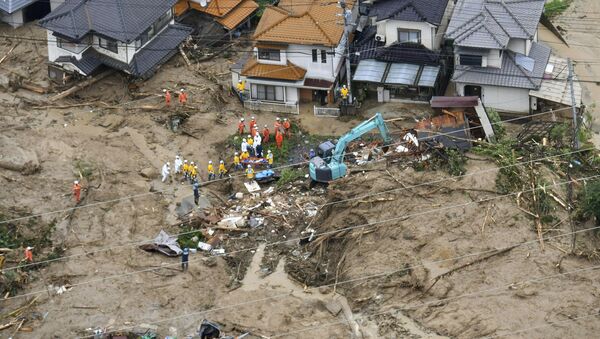 Rescue workers are seen next to houses damaged by a landslide following heavy rain in Hiroshima, western Japan, in this photo taken by Kyodo July 7, 2018 - Sputnik International