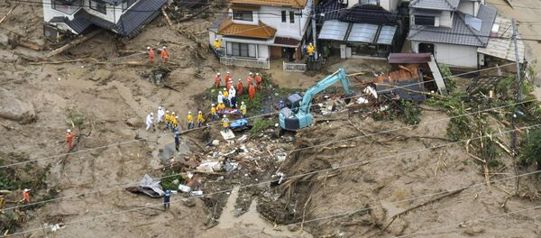 Rescue workers are seen next to houses damaged by a landslide following heavy rain in Hiroshima, western Japan, in this photo taken by Kyodo July 7, 2018 Rescue workers are seen next to houses damaged by a landslide following heavy rain in Hiroshima, western Japan, in this photo taken by Kyodo July 7, 2018 - Sputnik International