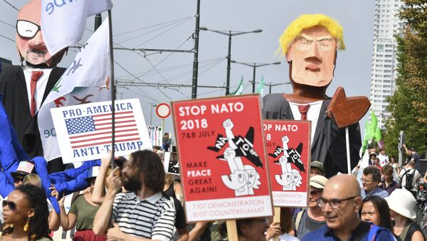 Protestors march next to giant puppets of U.S. President Donald Trump, right, and Belgian Prime Minister Charles Michel, left, during a demonstration in Brussels, Saturday, July 7, 2018 - Sputnik International